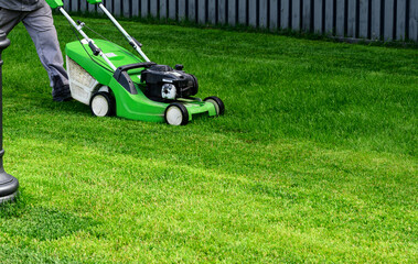Lawn mover on green grass in modern garden. Machine for cutting lawns.