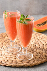 Asian Papaya lassi on gray background. Freshness cold beverage of yogurt, water, spices, fruits and...