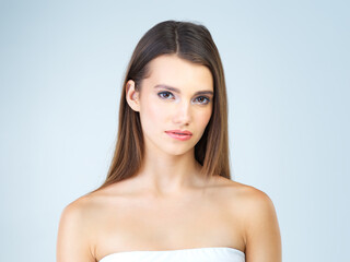 Beauty, skincare and serious with portrait of woman for cosmetics, self care and glow. Natural, satisfaction and makeup with cute girl model for confident, glow and attractive on blue background