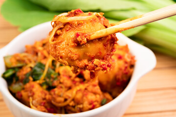 Fried dumplings in a white bowl. Made from wet dumplings that are sauteed with mustard greens, bean...