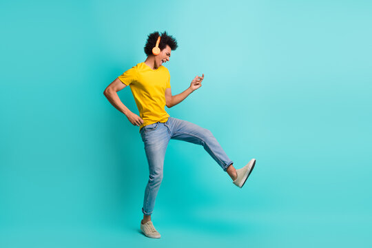 Full body portrait of crazy positive person arms play imagine guitar listen music headphones isolated on turquoise color background