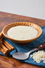 Delicious rice pudding or arroz con leche with cinnamon in bowl on wooden table