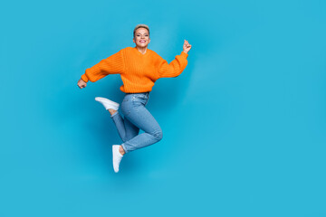 Fototapeta na wymiar Full length photo of shiny pretty dressed knitted pullover jumping high running fast empty space isolated blue color background