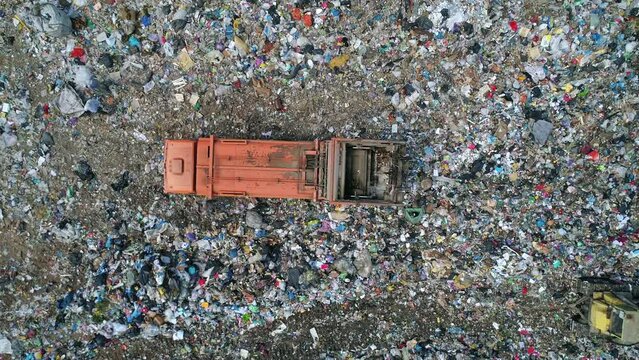 Aerial top down view of truck unloading garbage, waste at landfill. Trash truck dump waste products polluting in an trash dump.
