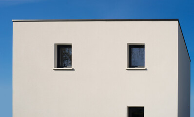 Fototapeta na wymiar Modern detached house cube with flat roof Modernes Einfamilienhaus mint Flachdach in Kubusform vor blauem Himmel