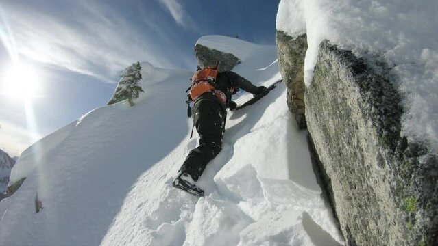 Mountaineer with Snowboard Climbing Mountain Cliff