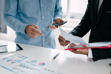 Business people are deeply examining financial reports for investment returns or investment risk...