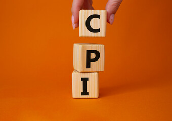 CPI - Consumer Price Index symbol. Concept word CPI on wooden cubes. Businessman hand. Beautiful grey background. Business and CPI concept. Copy space.