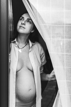 Une femme enceinte derri&egrave;re la fen&ecirc;tre