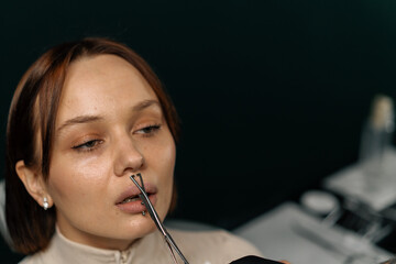 The piercing studio master pierces the lips with a needle