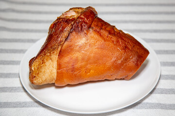 Smoked pork knuckle, traditional German dish, isolated portrait and in selective focus