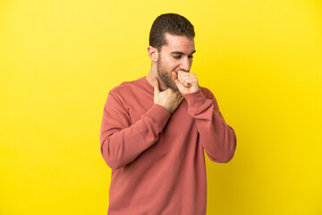 Handsome blonde man over isolated yellow background coughing a lot