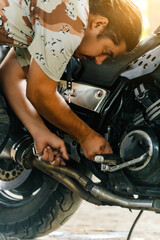 Fototapeta na wymiar Man working on a motorcycle with a wrench.