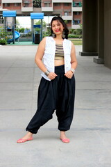 A lady dancer is posing for the photo. she is wearing black bottoms and white top with black and...