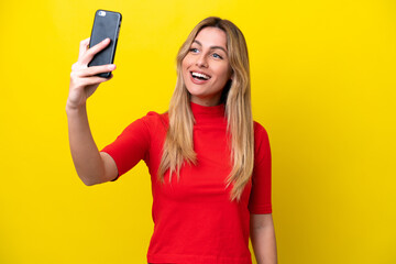 Naklejka premium Young Uruguayan woman isolated on yellow background making a selfie