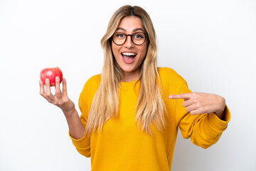 Young Uruguayan woman with an apple isolated on white background with surprise facial expression