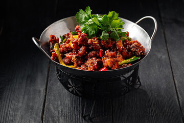 Chinese fried chicken with chili pepper in a wok pan
