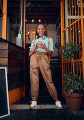 Cafe, student and phone social media with headphones on walk commute break in New York city. Happy urban college girl enjoying internet leisure on smartphone at doorway of local business.