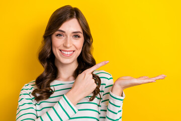 Photo of positive adorable lady toothy smile indicate finger arm hold empty space isolated on...