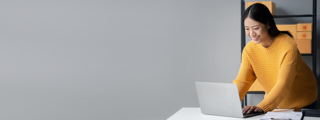 A beautiful business owner opens an online store, she is checking orders from customers, sending...