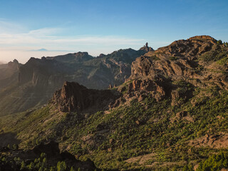 Fototapeta premium Aerial View of Rocky Mountains with Roque Nublo and Mount Teide in the Background in Gran Canaria, Spain