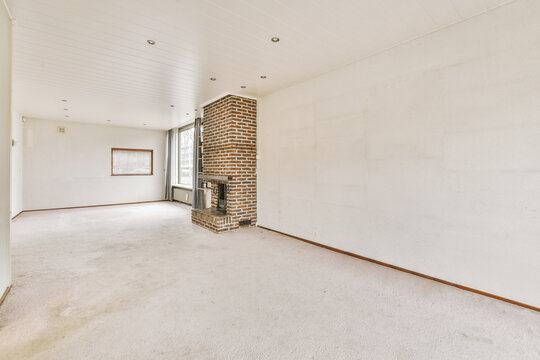 Empty spacious room with fireplace and window