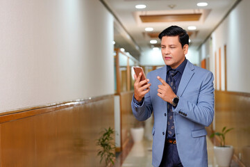 Indian businessman using smartphone at office.