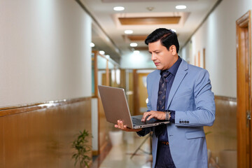 Indian businessman using laptop at office.