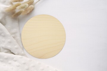 Wood texture baby name sign, round wooden milestone disc mockup, bunny tail grass, soft blanket,  space for text, top view.