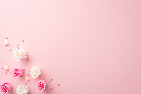 Mother's Day atmosphere concept. Top view photo of white and pink rose buds small hearts and sprinkles on isolated pastel pink background with copyspace