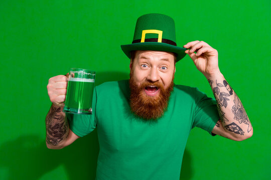 Photo of funky impressed man wear t-shirt headwear drinking ale beverage enjoying shamrock day isolated green color background