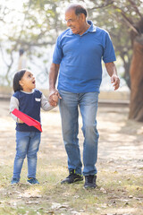 Fototapeta premium Carefree grandfather having fun with granddaughter at park