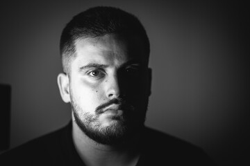 Grayscale portrait of a young Caucasian male with a serious face