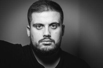 Grayscale portrait of a young Caucasian male with a serious face