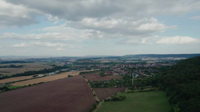 Aer ial view of a German village surrounded by meadows, farmland and forest in Germany.