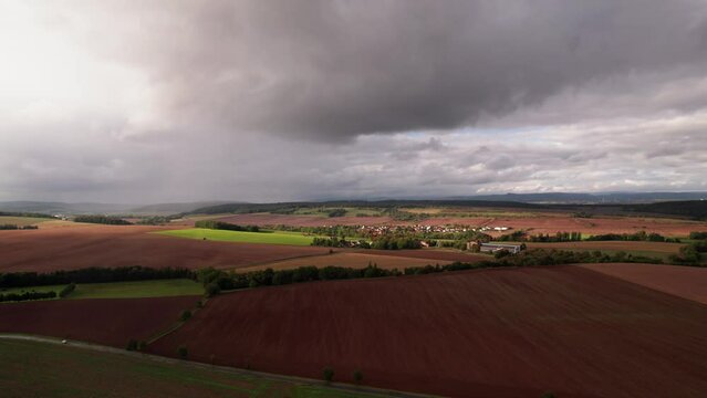 Aer ial view of a German village surrounded by meadows, farmland and forest in Germany.