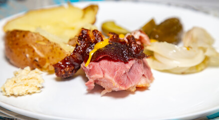Roasted smoked pork knuckle with typical side dishes, traditional German dish, isolated portrait in selective focus.