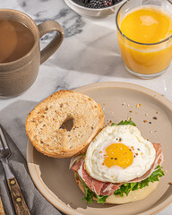 bagel sandwich with ham and egg on plate