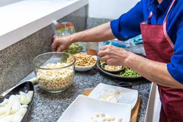 Unrecognizable woman preparing legumes to cook fanesca