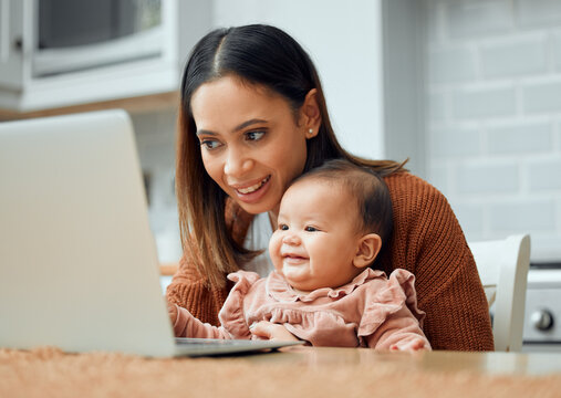 The best company for a working mom. Cropped shot of an attractive young woman working at home with her newborn baby sitting on her laptop.