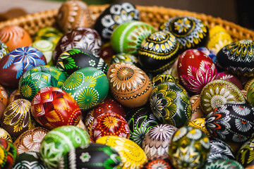 Traditional Lithuanian wooden colorful Easter eggs in a wicker basket, symbol of fertility and life painted with the symbols of nature