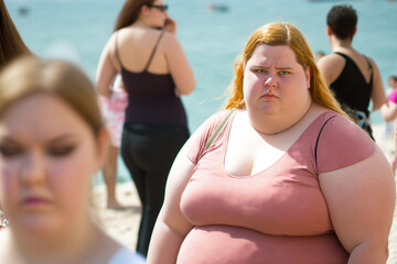 bad vacation, dissatisfied overweight young teenage girl in a bad mood on the beach, fictional person an - obrazy, fototapety, plakaty