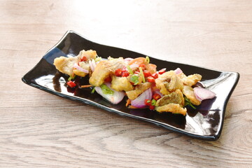 deep fried slice snake skin gourami spicy and sour Thai salad on plate