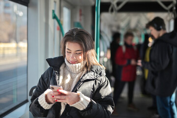 young woman on a tram uses a smartphone