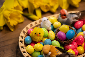 Fototapeta na wymiar Easter floral colorful eggs composition with chick, rabbit, bird on wooden table