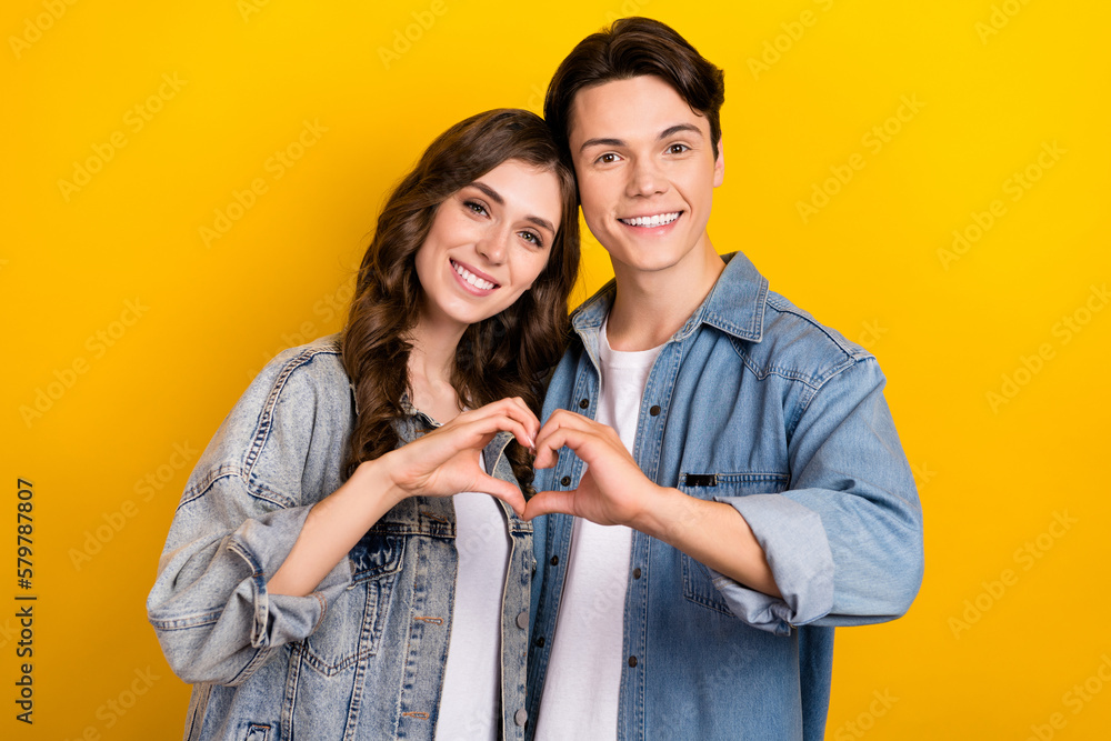 Poster Portrait of two peaceful idyllic partners arms fingers show heart symbol isolated on yellow color background