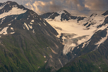 Girdwood Alaska, USA - July 23, 2011: White glacier on top of black rock mountain range in Chugach...