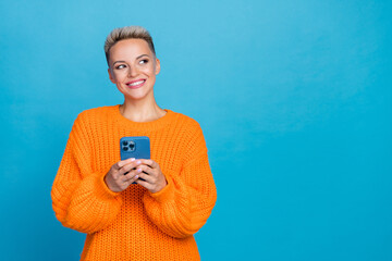 Photo of sweet dreamy woman dressed knitted pullover writing apple samsung modern device empty space isolated blue color background