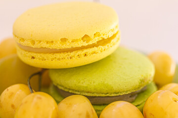 Fresh-tasting summer dessert – green, yellow fruit macarons, yellow cherried and fruit macro