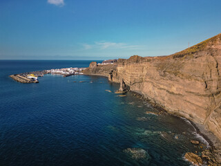 Fototapeta na wymiar Aerial view of beach and port in traditional whitewashed village, Puerto de las Nieves, Agaete, with cliffs in the northern coast of Gran Canaria, Spain